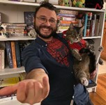 Headshot of Academic holding cat with spider man tshirt on Headshot of Academic holding cat with spider man tshirt on