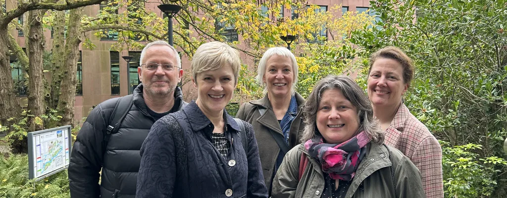 A group of cluster members against a leafy background A group of cluster members against a leafy background