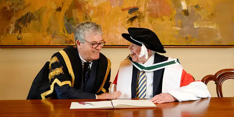 UCC president, Professor John O'Halloran (left) enjoys a light moment with Honorary Conferring recipient, Jim Corr while signing the UCC guest book