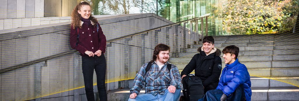 Access UCC Photoshoot - Three students sitting at the steps outside in UCC