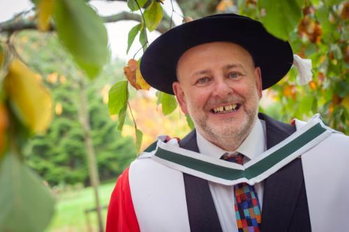 A man in ceremonial graduation robes 