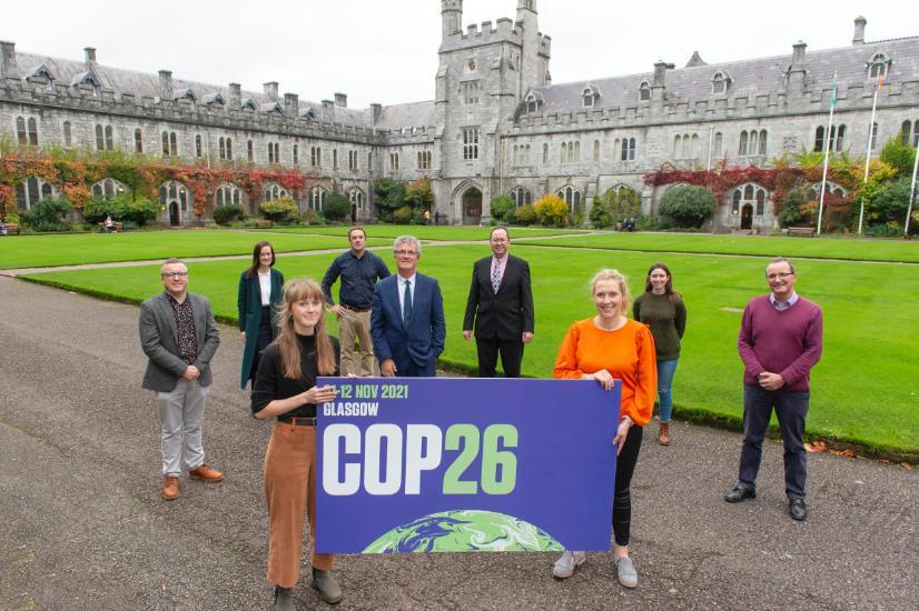 A group of people standing with a COP26 banner in UCC's Quad