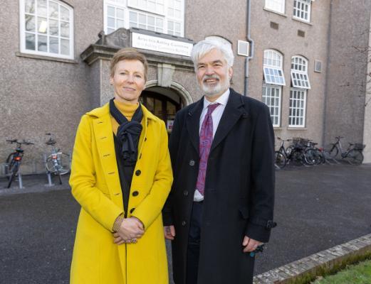 A man and a woman standing outside an academic builidng,