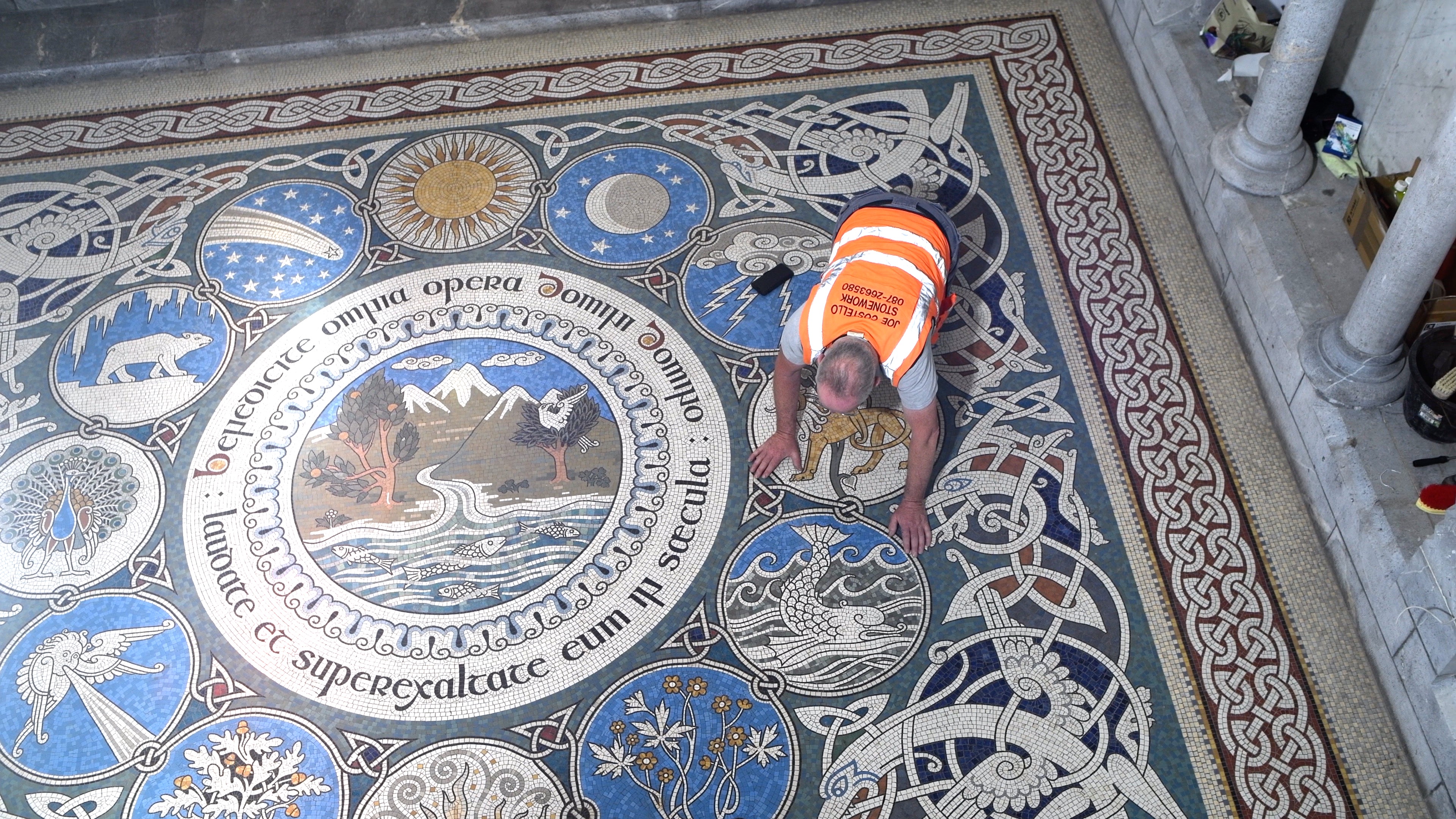 An overhead shot of a man working on a mosaic floor