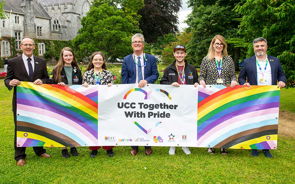 UCC community members together with pride in front of Pride banner in President's Garden UCC