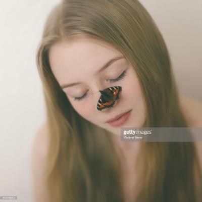 A woman with a butterfly on her nose