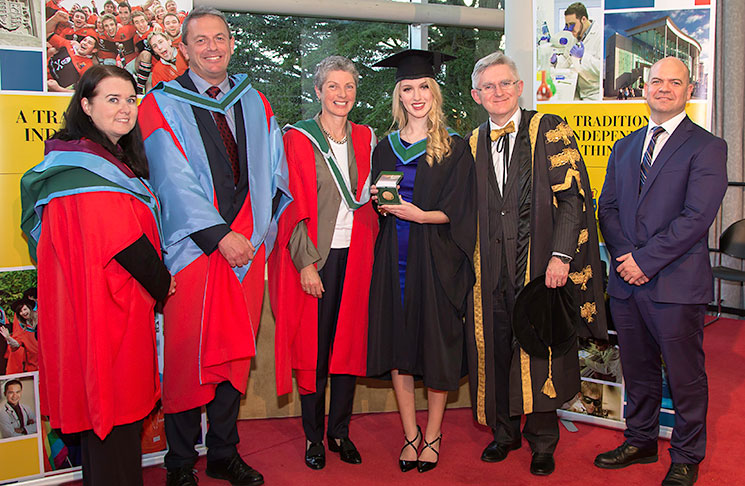 Dr Sinéad Kerins, School of Biochemistry and Cell Biology, University College Cork (UCC); Professor Paul Ross, Head of College College of Science, Engineering and Food Science, UCC; Professor Rosemary O’Connor, School of Biochemistry and Cell Biology, UCC; The 2017 Art Champlin Gold Medal recipient & top BSc in Biochemistry graduate in 2017, Carolyn Murray; Professor Patrick O’Shea, 15th President of UCC; and Mr John Rea, Vice President Global Business Unit Leader, Health Division at DuPont Nutrition & Health, Cork, Ireland.