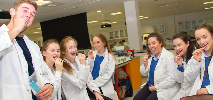Tom Morehead (4th Year Biochemistry) and students from Christ King Girls’ Secondary School pictured swabbing their cheek cells for DNA extraction experiment