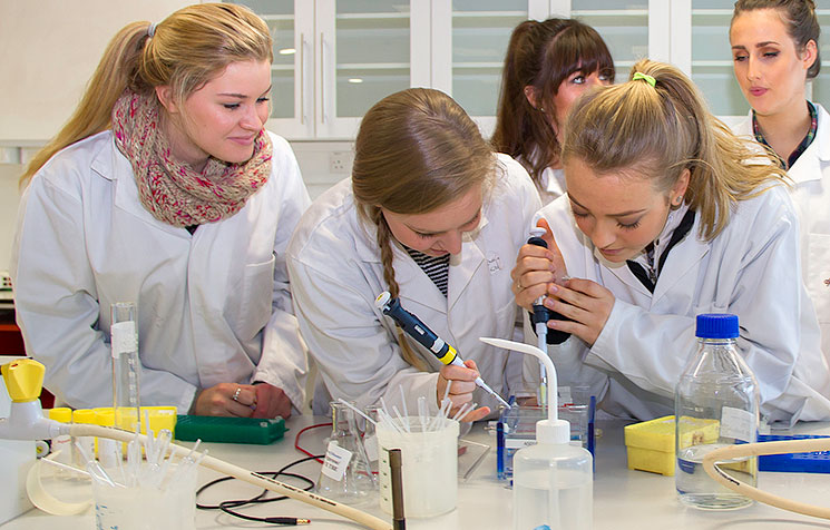 Christina Killian, 4th Year Biochemistry (centre) demonstrating to secondary school students from Bandon Grammar School, Cork