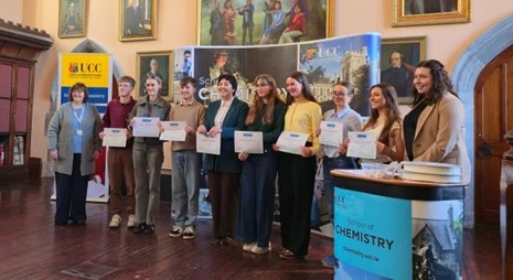 A line of students hold certificates for awards won at the poster session.