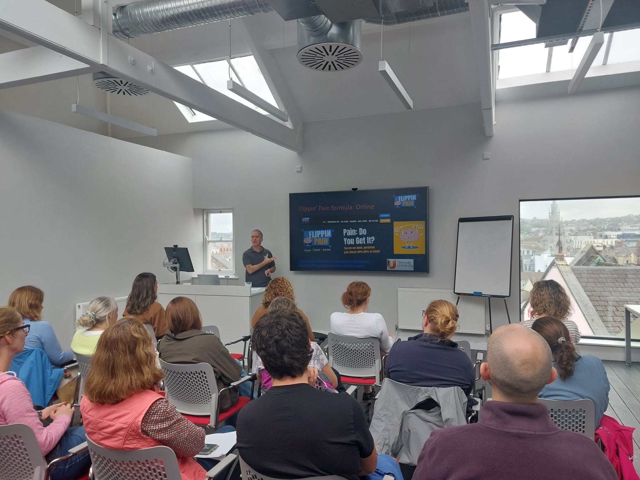 Cormac Ryan talking about Flippin Pain with several seated participants infront of him Cormac Ryan talking about Flippin Pain with several seated participants infront of him