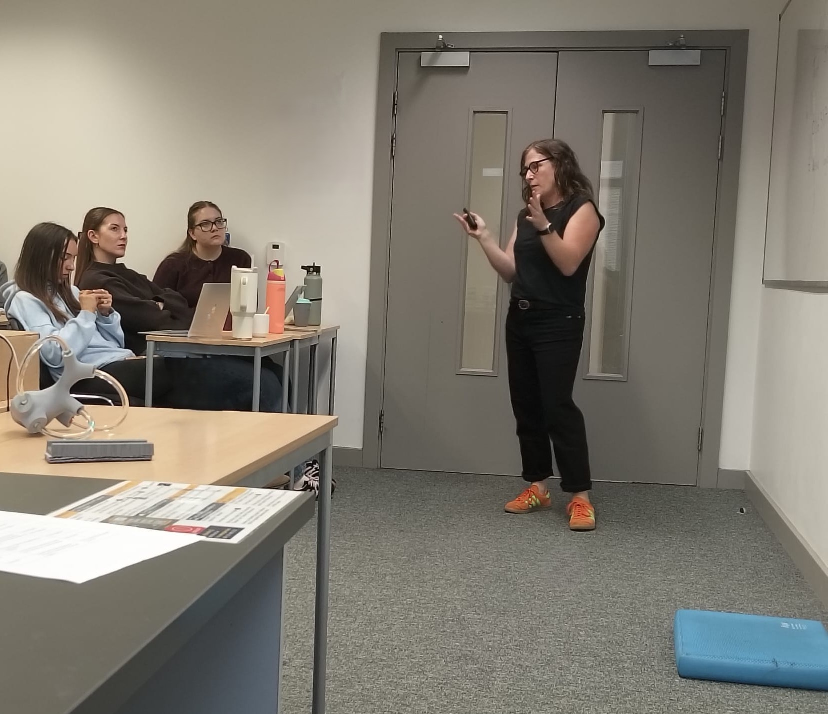 Female lecture infront of students in a classroom Female lecture infront of students in a classroom