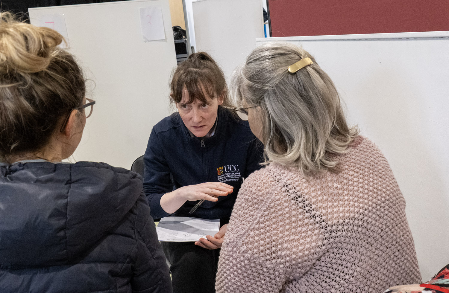 Student together with two patients sitting down Student together with two patients sitting down