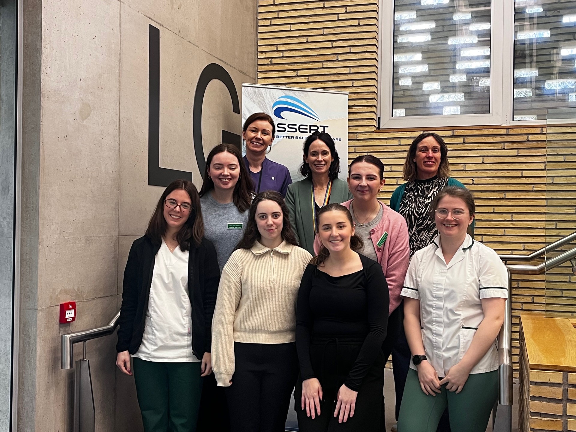 Group photo of attendees standing on the stairway in the Assert Building Group photo of attendees standing on the stairway in the Assert Building