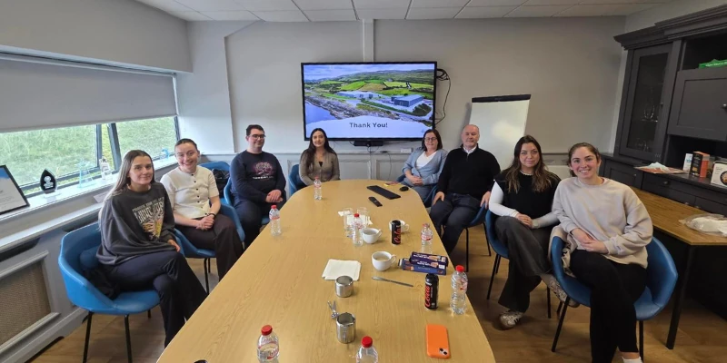 Image of people posing for a photo around a table in a meeting room Image of people posing for a photo around a table in a meeting room