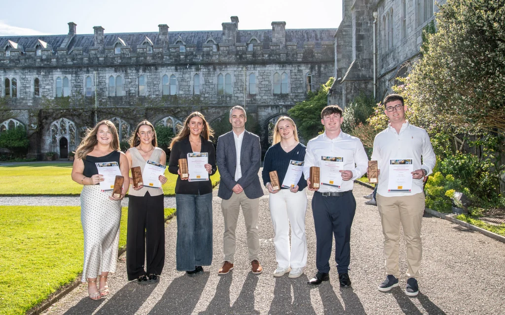 Image of people smiling and posing with awards on UCC quad