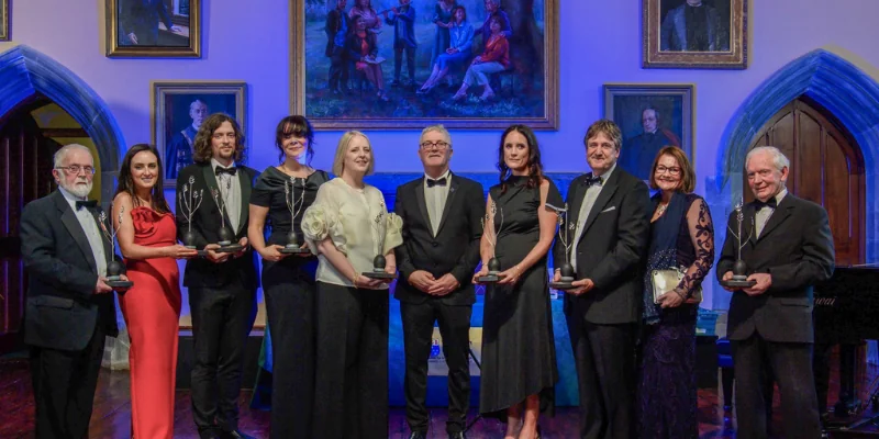 Image of several people smiling and holding awards Image of several people smiling and holding awards