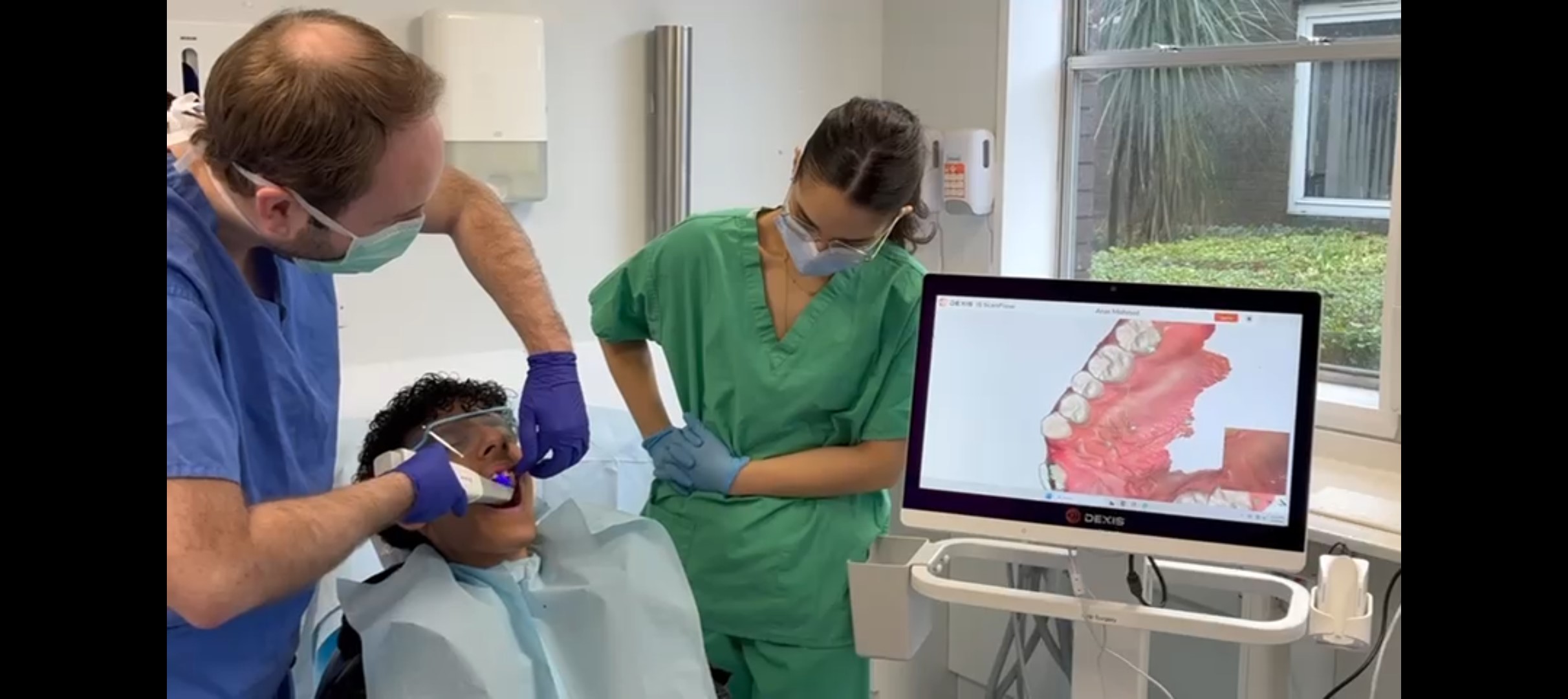 Clinician and Student using intraoral scanner on patient. 