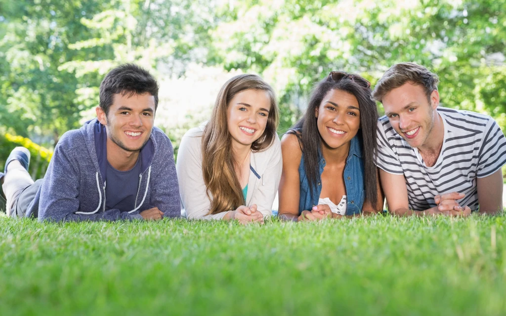 4 students lying on the grass