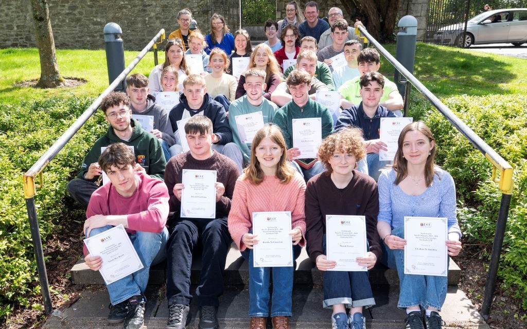 Students and staff members sitting on steps