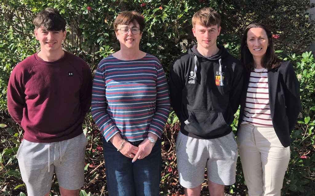 Ceathrar ina seasamh taobh amuigh de scoil