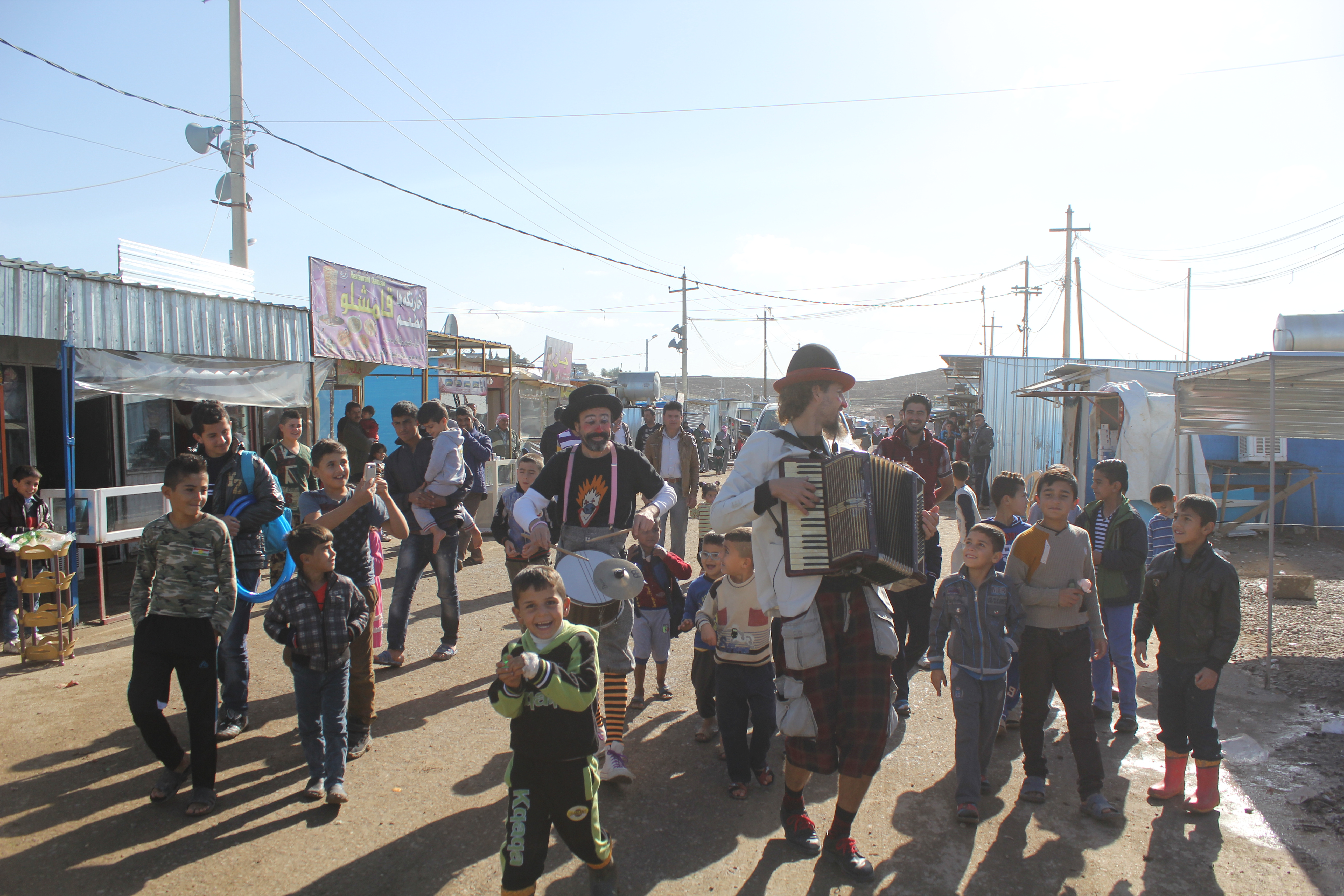 Performers with Clowns Without Borders get children involved in a show at Kawergosk Refugee Camp.   © UNHCR/M. Prendergast