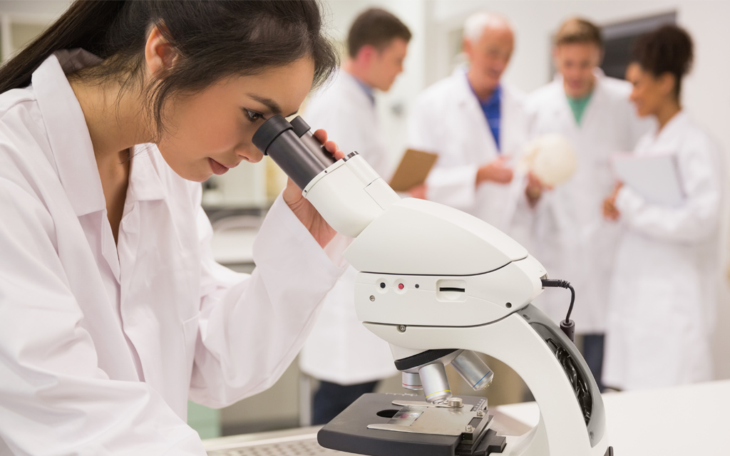 Female researcher looking into a microscope