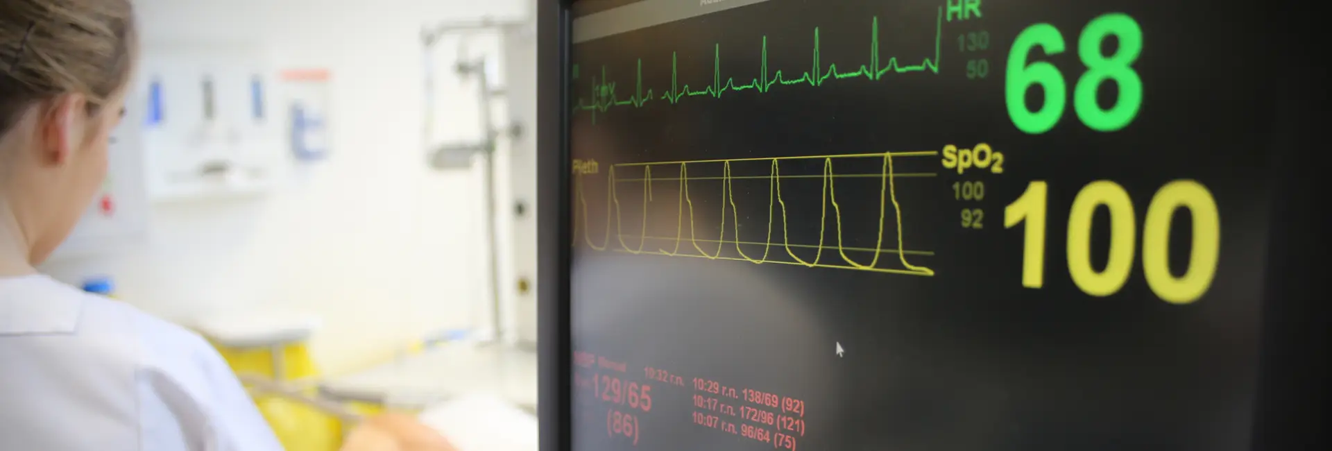 student nurse alongside mannequin and vitals screen