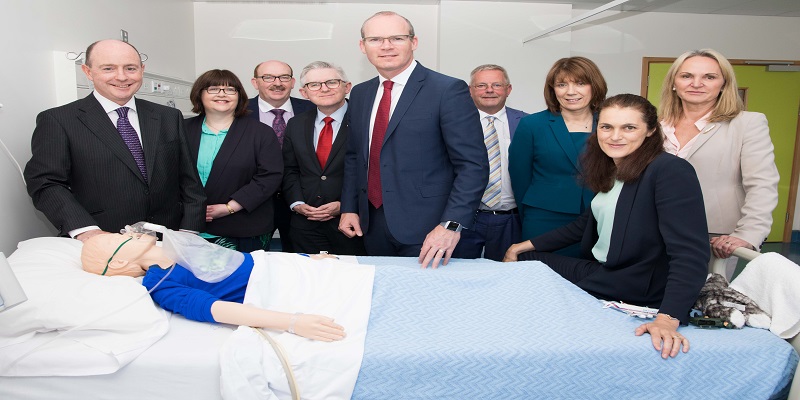 Prof Jonathan Hourihane, Ms Anita McGuire,Mr Gerry O'Dwyer, Mr Patrick O'Shea, Mr Simon Coveney, Mr Tony McNamara, Prof Geraldine Boylan, Prof Deirdre Murray and Prof Helen Whelton look at paediatric simulation manikin in training room