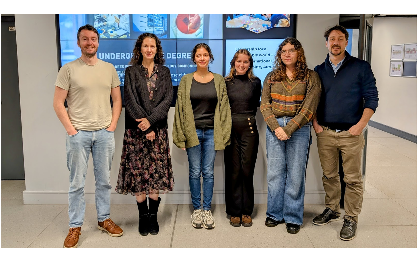 6 committee members standing in front of screen