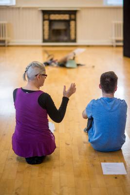 Theatre lecturer teaching on the ground with her students