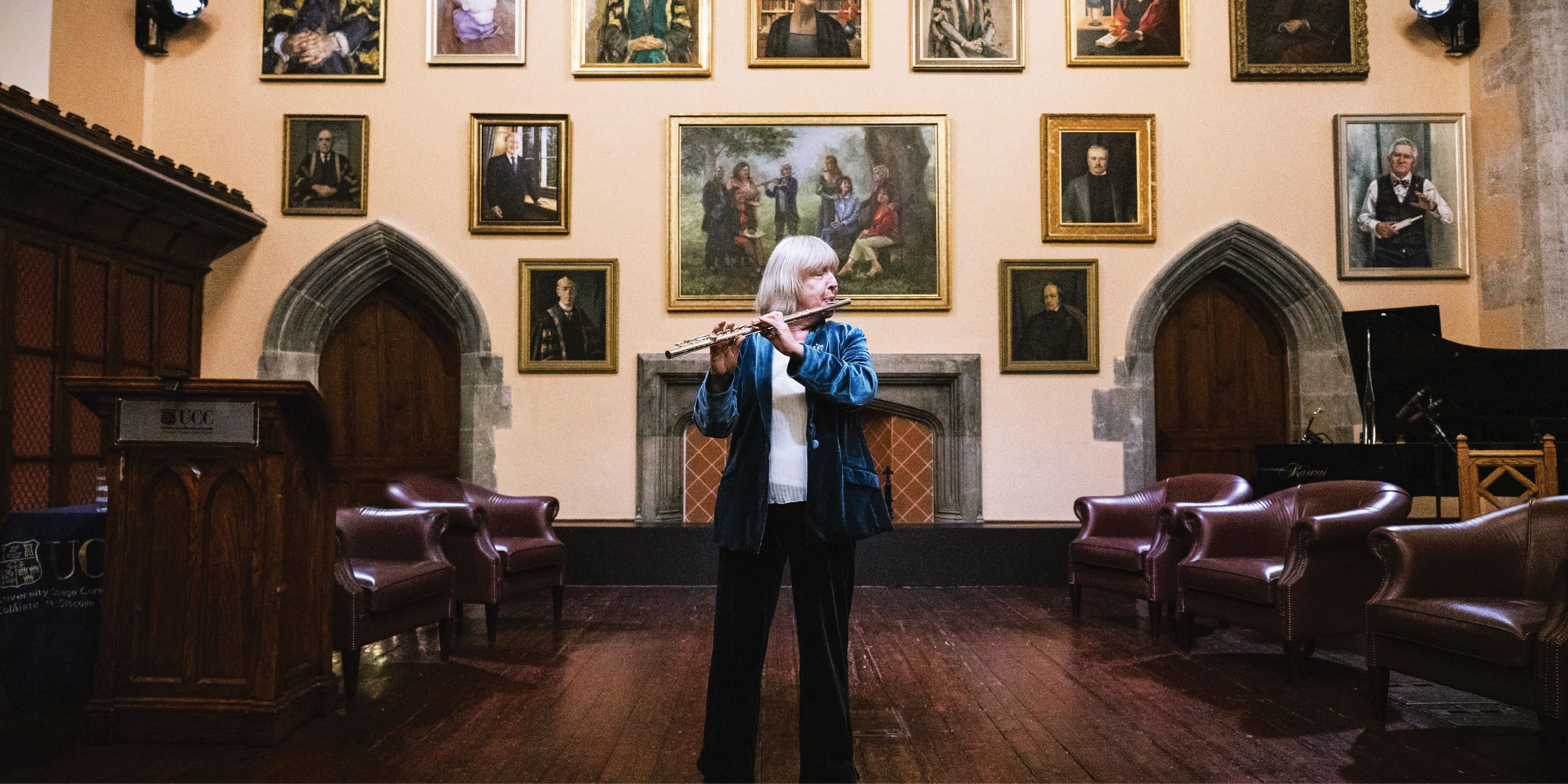 The cover of the Philanthropy Impact Report 2024-25 features Dr Evelyn Grant performing in front of newly unveiled portraits in the Aula Maxima as part of Accenture’s Women on Walls ‘In Conversation’ Event at UCC.