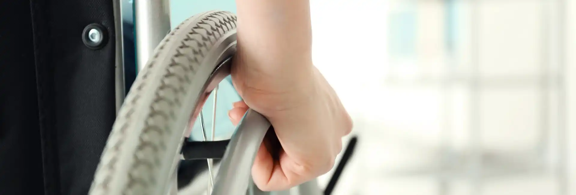 close up of a hand on the wheel of a wheelchair