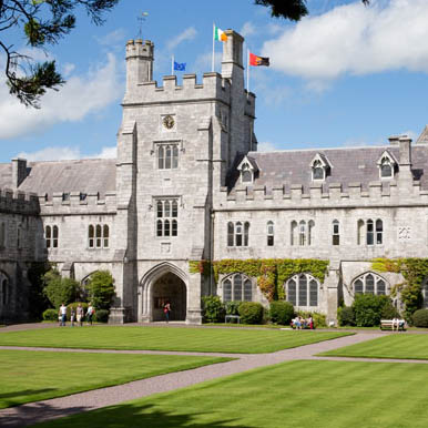 The Quad with flags on the clock tower on a sunny day with trees
