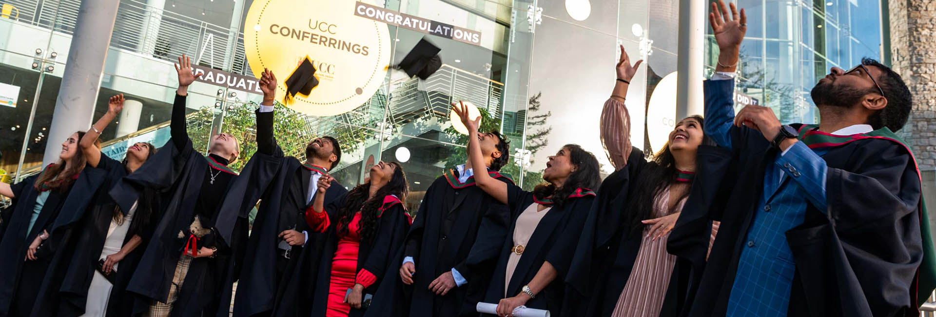 Graduates throwing their caps in the air wearing gowns