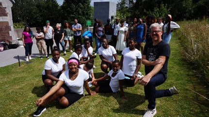 a group of students sitting in a grassy area