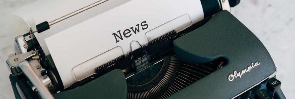 A typewriter, the paper sticking out reads 