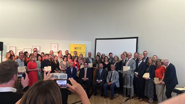 A large group of people at an awards ceremony posing for photographs