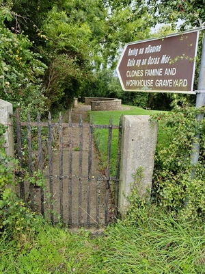 A sign post in the countryside pointing towards an old metal gate A sign post in the countryside pointing towards an old metal gate