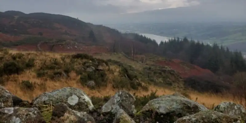 A rocky and boggy hilly landscape overlooking a grey river A rocky and boggy hilly landscape overlooking a grey river