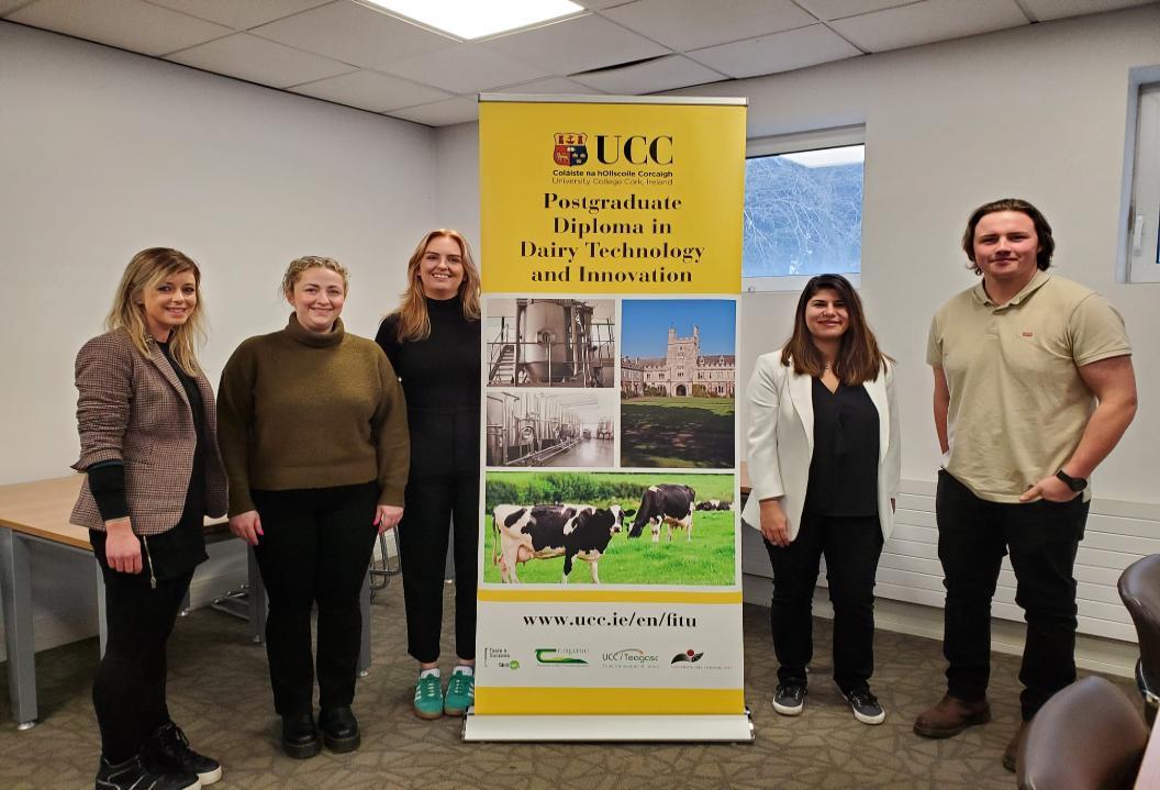 A group of students and Lecturers standing around a sign for the Diploma in Dairy Technology and Innovation