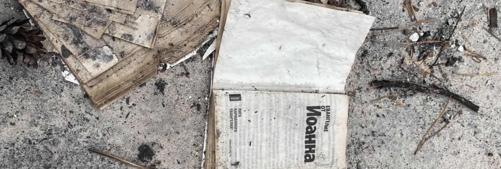 a book lying on the street with charred edges from fire
