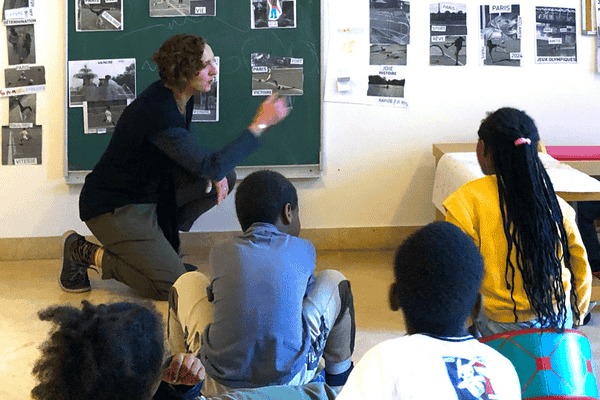 A women points to graphics in front of an audience of young people