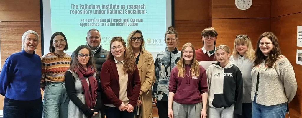 Group of smiling people in front of a screen at the Pathology Institute as Research Repository Under National Socialism Event at UCC Group of smiling people in front of a screen at the Pathology Institute as Research Repository Under National Socialism Event at UCC