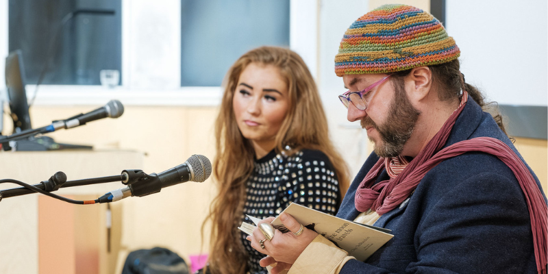 Oein DeBhairduin reads an extract from his book: Why the moon travels, watched on by Rosie McCarthy at an Evening of Socially Engaged Music & Spoken Word as part of the Festival of Social Science. Photo by Marcin Lewandowski.