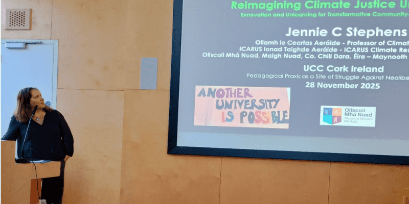 A women at the lectern in The Shtepps presents slides on a screen to the audience