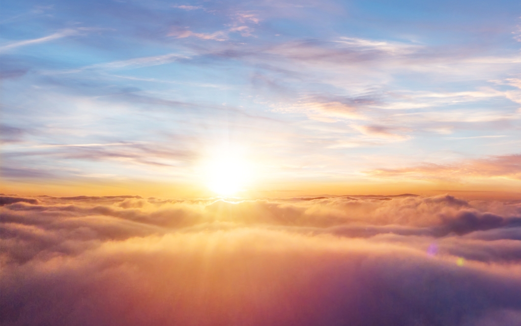 Beautiful sunset sky above clouds with dramatic light. Cabin view from airplane