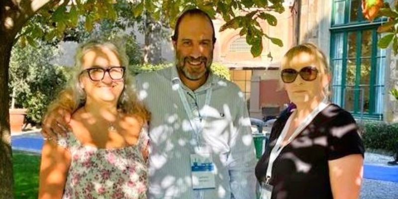 Three people standing for a photograph, smiling