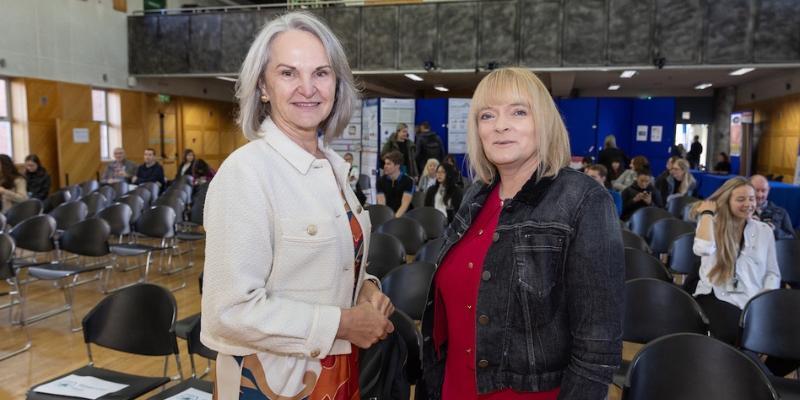 Two women standing smiling for a photograph