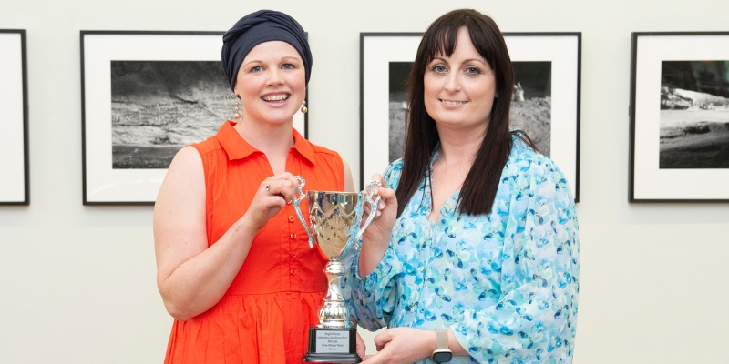 Two women holding a trophy